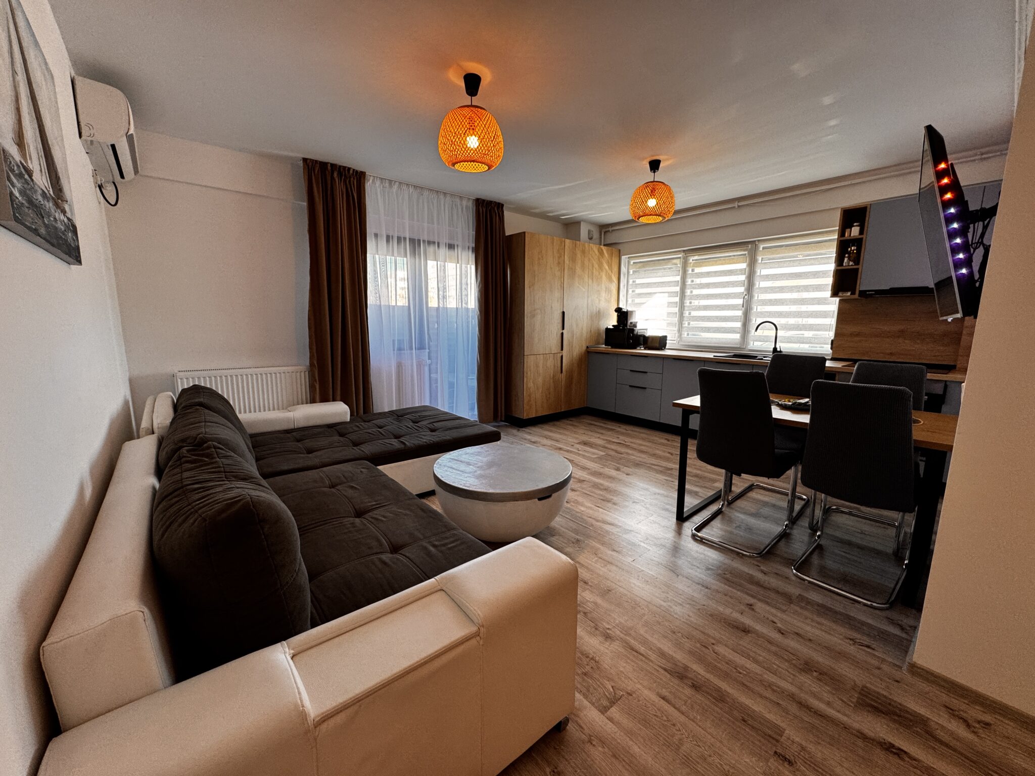 Experimentați viața modernă în acest apartament cu 2 camere din Mamaia Nord, dotat cu o canapea modulară elegantă, o masă de cafea rotundă, o zonă de luat masa, parchet și ferestre mari cu jaluzele. Luminile calde de tavan oferă o iluminare delicată în tot spațiul.